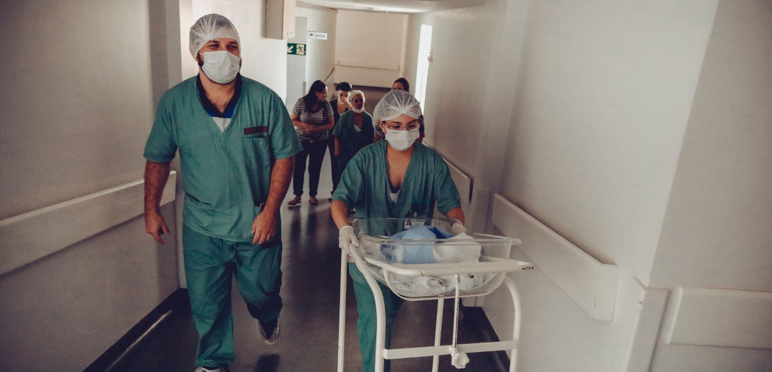 Medical professionals pushing medical trolley in hospital corridor