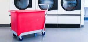 Red plastic tub trolley in commercial laundry facility